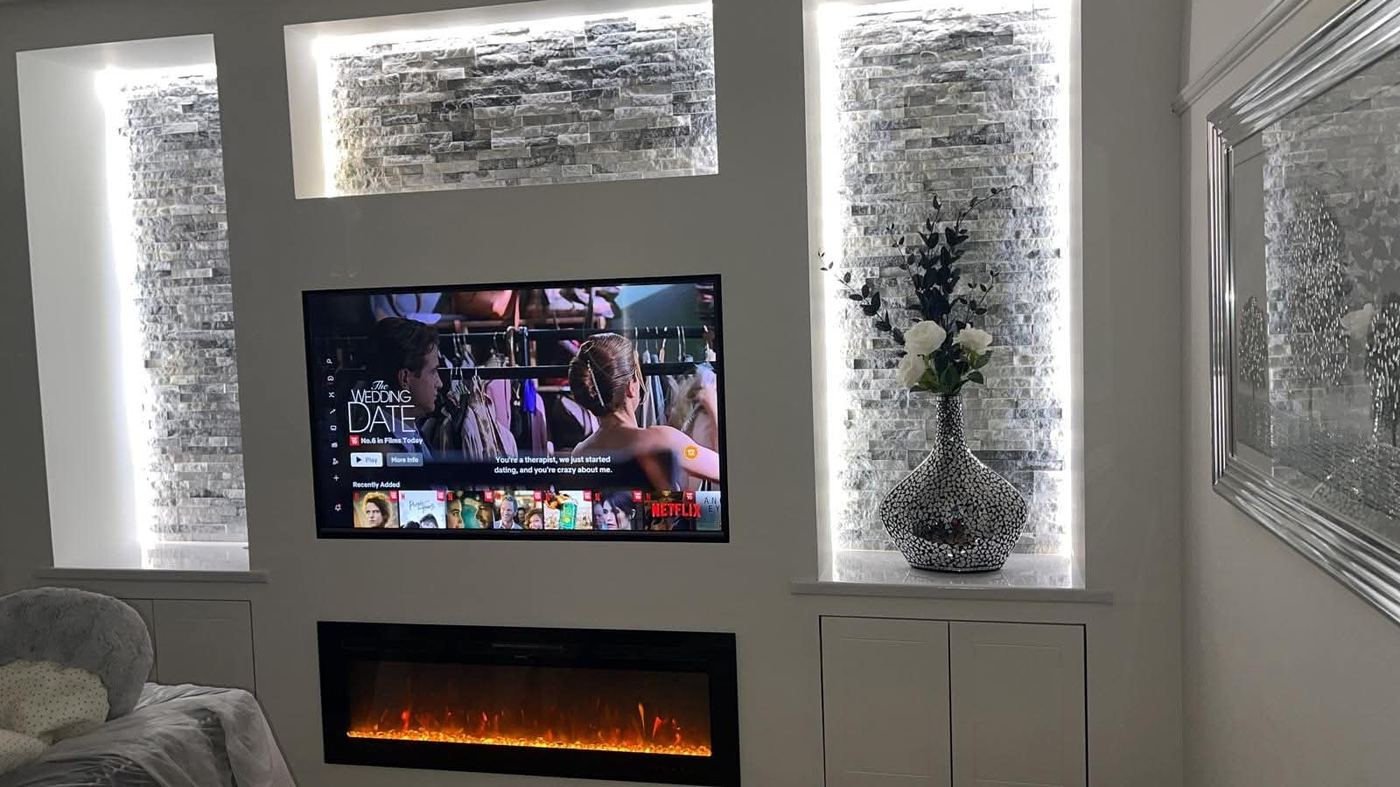Media wall with open floating shelving either side of the recessed TV
