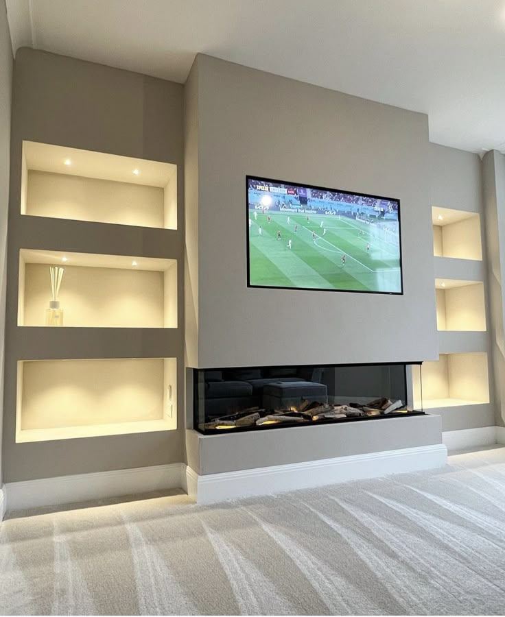 Media wall with open display shelving either side of the TV and an inset electric fire