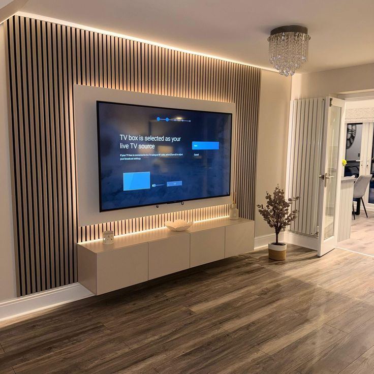 Full-width vertical slat panel media wall with a floating cabinet beneath the TV