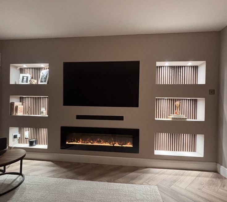 Media wall with stone-clad feature columns either side of the TV and an inset electric fire